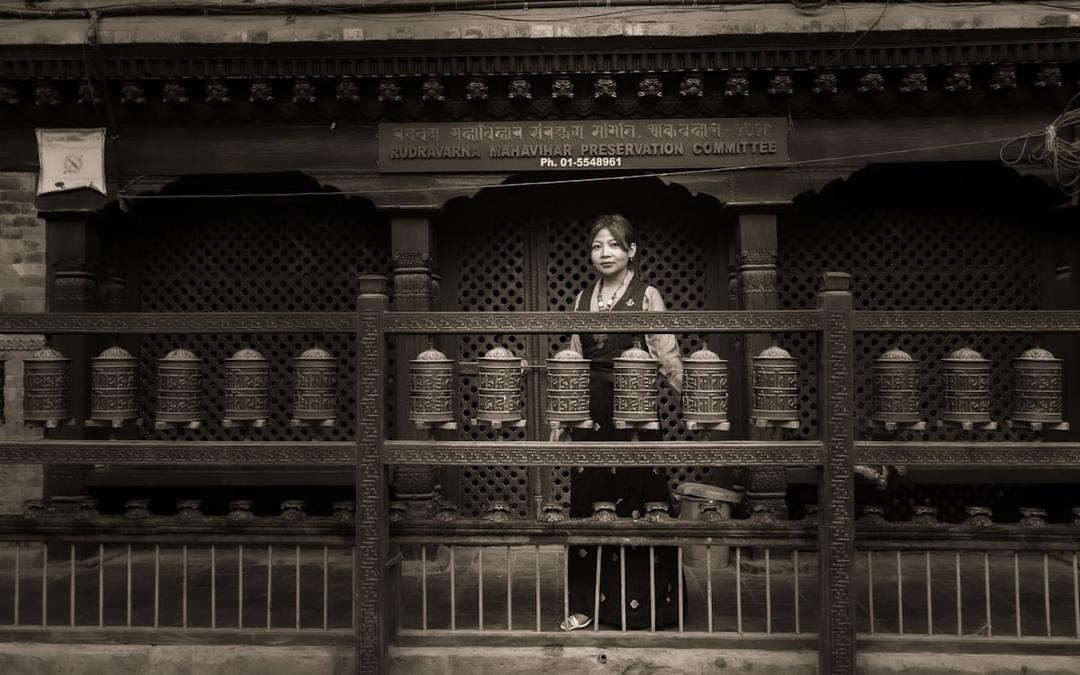 Woman turning prayer wheels at a Buddhist temple, one of many sacred sites in the tradition